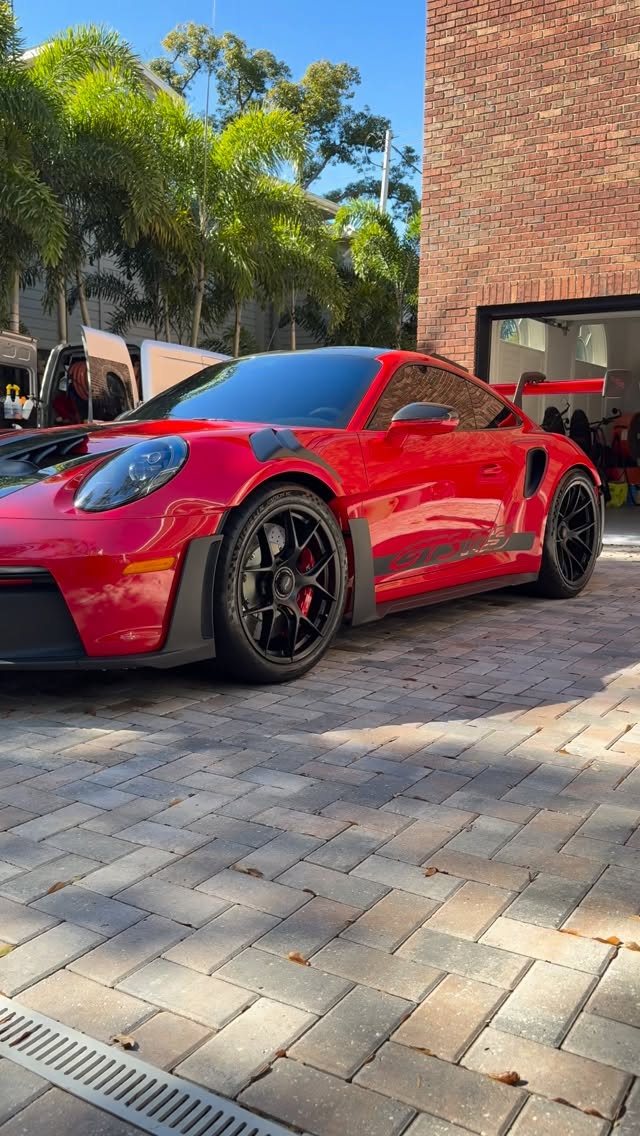 Red Porsche GT3 RS with flawless paint on paver driveway